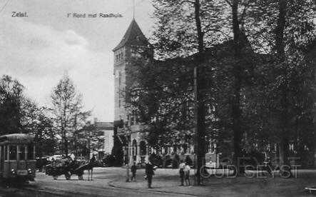 't Rond-1922-003.jpg - Het Gemeentehuis van Zeist aan het Rond vanaf de Donkerelaan. Gebouwd in 1908 door architect Jan Stuivinga. Op de foto komt een electrischetram voorbij op weg naar het Stationsplein. Er staat ook een paard en wagen van de firma van Laar op de foto. Deze had een groentehandel op de Oude Arnhemseweg. Opname van 1922.